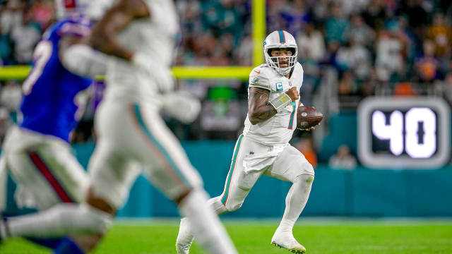Miami Dolphins quarterback Tua Tagovailoa (1), runs away from the Buffalo Bills defense during NFL football game Jan 07, 2024, in Miami Gardens.