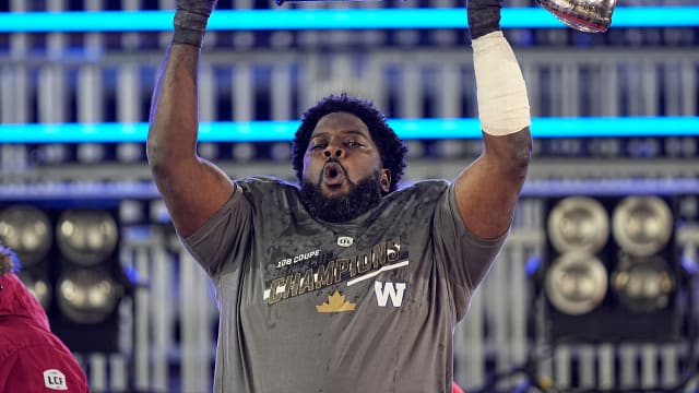 Dec 12, 2021; Hamilton, Ontario, CAN; Winnipeg Blue Bombers offensive lineman Stanley Bryant (66) hoists the Grey Cup after defeating the Hamilton Tiger-Cats in the 108th Grey Cup football game at Tim Hortons Field. Mandatory Credit: John E. Sokolowski-USA TODAY Sports  