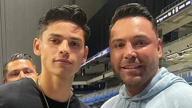 Ryan Garcia and Oscar De La Hoya pose for the camera behind the scenes at a boxing event.