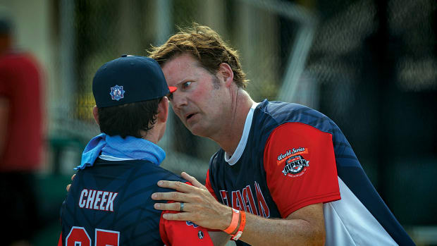 Ben Cheek talks with his father after an inning of pitching during morning action of the Cal Ripken U10 World Series tournament play at Gardens Park in Palm Beach Gardens, Fla.