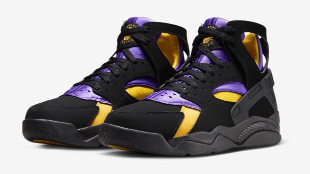 Side view of black, purple, and gold Nike Huarache shoes.
