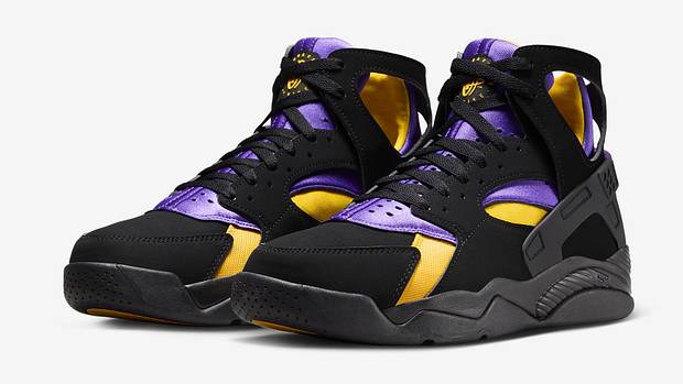 Side view of black, purple, and gold Nike Huarache shoes.