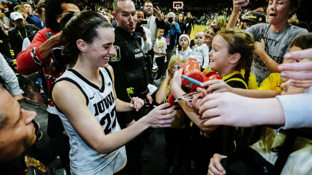 Iowa Hawkeyes guard Caitlin Clark gives her Nike Kobe sneakers to a fan.