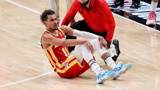 Trae Young is attended to after injuring his ankle.