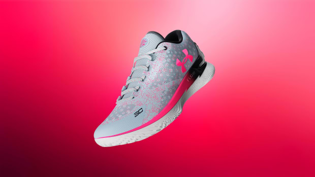 Side view of grey and pink Under Armour shoe.