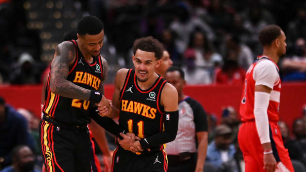 Trae Young celebrates with John Collins after making a shot.