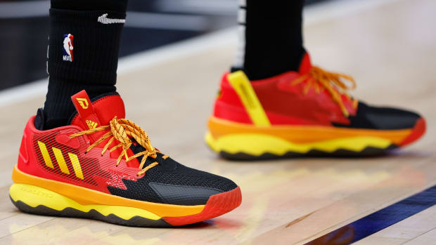 Red, black, and yellow Adidas Dame shoes.