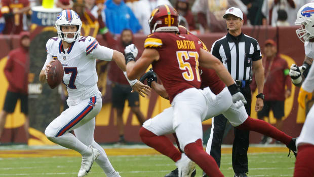 Buffalo Bills quarterback Josh Allen runs with the ball in a game against the Washington Commanders.