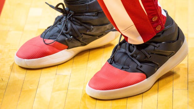 Side view of an Indiana Hoosiers basketball player's black and red adidas sneakers.