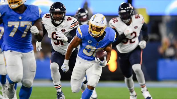 Los Angeles Chargers running back Austin Ekeler (30) runs the ball against Los Angeles Chargers defensive tackle Christopher Hinton (91) and linebacker Khalil Mack (52) during the second quarter at SoFi Stadium.