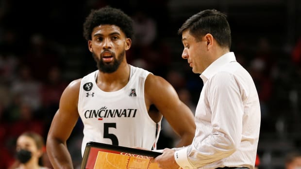 Cincinnati Bearcats head coach Wes Miller talks with guard David DeJulius (5) during a timeout in the second half of the NCAA basketball game between the Cincinnati Bearcats and the Tennessee Tech Golden Eagles at Fifth Third Arena in Cincinnati on Tuesday, Dec. 21, 2021. Cincinnati finished its non-conference schedule with a 76-67 win over the Golden Eagles. Tennessee Tech Golden Eagles At Cincinnati Bearcats Basketball