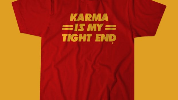 A red and yellow shirt with "Karma is my tight end."