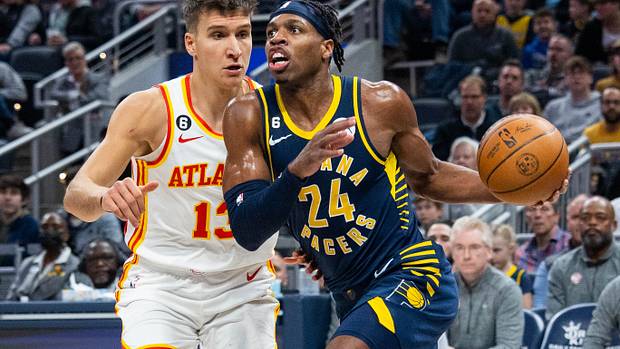 Pacers guard Buddy Hield dribbles past Hawks guard Bogdan Bogdanovic.
