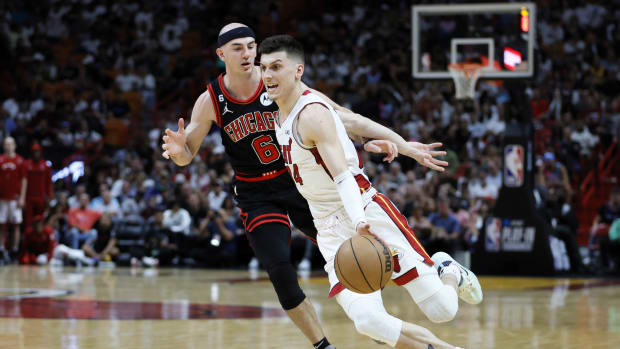 Miami Heat guard Tyler Herro (14) dribbles the basketball ahead of Chicago Bulls guard Alex Caruso (6)