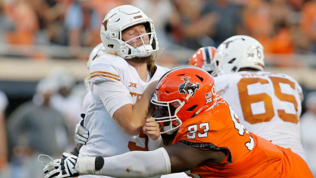 Oklahoma State Cowboys defensive tackle Collin Clay (93) hots Texas Longhorns quarterback Quinn Ewers (3) after a pass during a college football game between the Oklahoma State Cowboys (OSU) and the Texas Longhorns