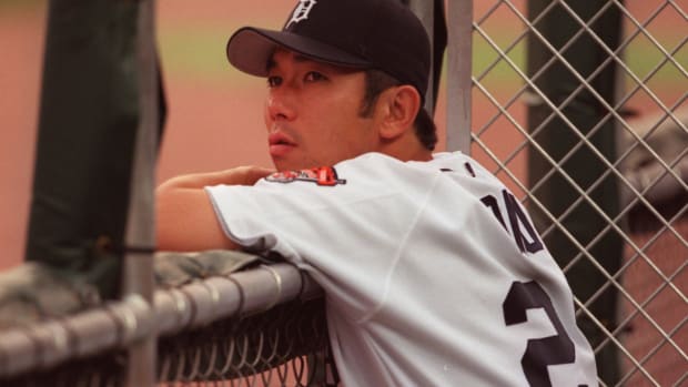 Detroit Tigers pitcher Hideo Nomo watches the game from the dugout.