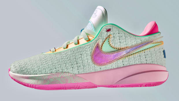 View of pink and teal Nike LeBron 20 shoes.