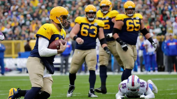 Green Bay Packers quarterback Aaron Rodgers runs past Buffalo Bills defenders.