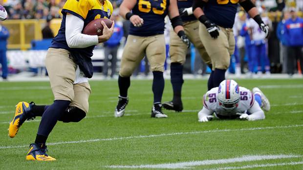 Green Bay Packers quarterback Aaron Rodgers runs past Buffalo Bills defenders.