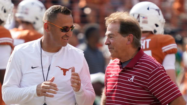 Steve Sarkisian and Nick Saban talk before a game