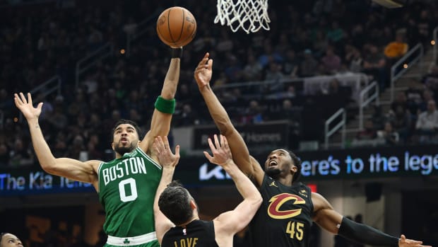 Boston Celtics forward Jayson Tatum competes for a rebound with Cleveland Cavaliers guard Donovan Mitchell