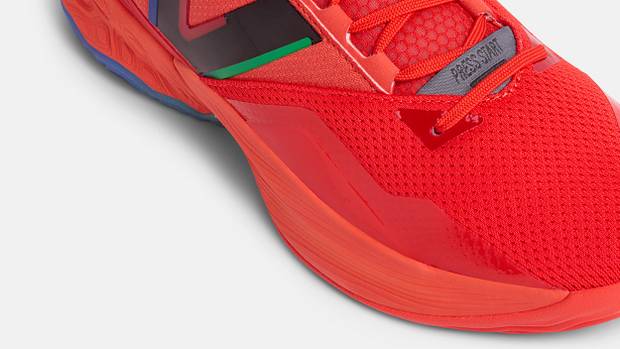 Side view of a red and black New Balance basketball shoe.