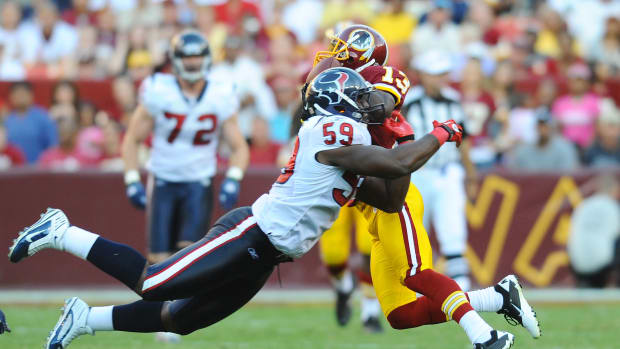 Redskins wide receiver Anthony Armstrong (13) catches a pass as Houston Texans linebacker DeMeco Ryans (59) defends in the second half at FedEx Field.