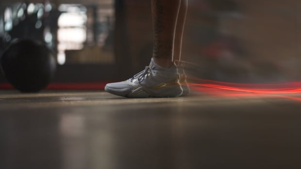 Side view of Patrick Mahomes' grey and gold adidas shoes.