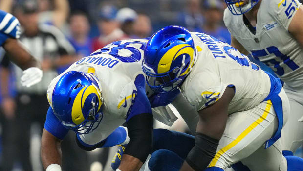Indianapolis Colts quarterback Anthony Richardson (5) falls down and is tackled by Los Angeles Rams defensive tackle Aaron Donald (99) and defensive tackle Kobie Turner (91) during the first half of the game Sunday, Oct. 1, 2023, at Lucas Oil Stadium in Indianapolis.