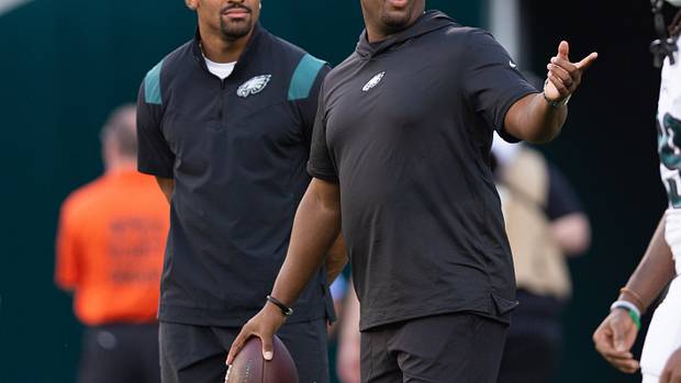 Philadelphia Eagles offensive coordinator Brian Johnson talks with Jalen Hurts before a game against the Cleveland Browns at Lincoln Financial Field.