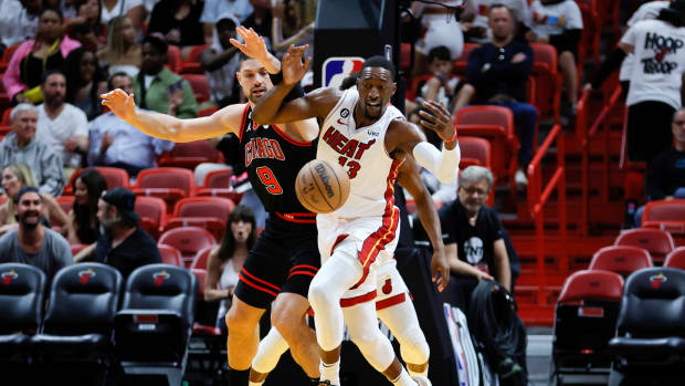 Apr 14, 2023; Miami, Florida, USA; Miami Heat center Bam Adebayo (13) and Chicago Bulls center Nikola Vucevic (9) battle for possession during the first quarter at Kaseya Center.