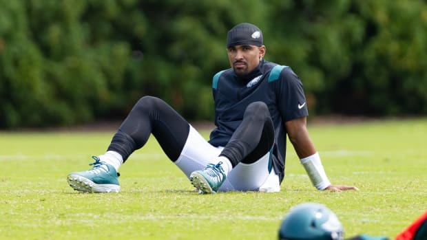 Philadelphia Eagles quarterback Jalen Hurts sits on the ground during practice.