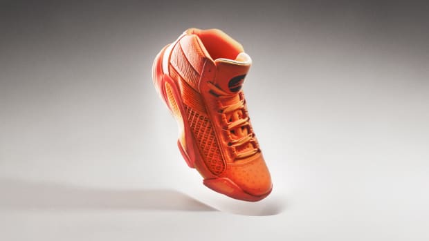 Side view of an orange and black Air Jordan basketball shoe.