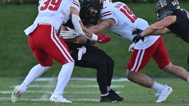 Wisconsin linebacker Tate Grass and Nick Herbig combining for a tackle against Northwestern.