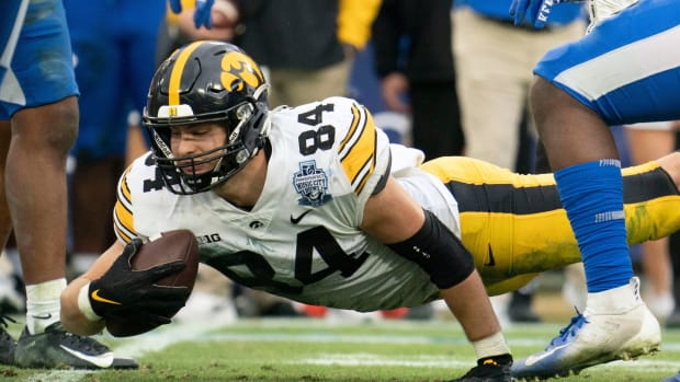 Iowa tight end Sam LaPorta (84) dives for extra yards past Kentucky defenders during the third quarter of the TransPerfect Music City Bowl at Nissan Stadium Saturday,