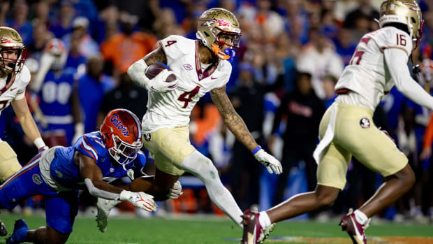 Florida State Seminoles wide receiver Keon Coleman (4) rushes with the ball for a touchdown breaking the tackle from Florida Gators linebacker Scooby Williams (17) during the second half at Steve Spurrier Field at Ben Hill Griffin Stadium in Gainesville, FL on Saturday, November 25, 2023. [Matt Pendleton/Gainesville Sun]