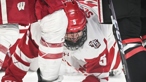 Wisconsin defenseman Zach Schulz (5) gets tangled between a teammate and a Northeastern player during the third period of the championship game of the Kwik Trip Holiday Face-Off on Friday, December 29, 2023, at Fiserv Forum in Milwaukee, Wisconsin.  
