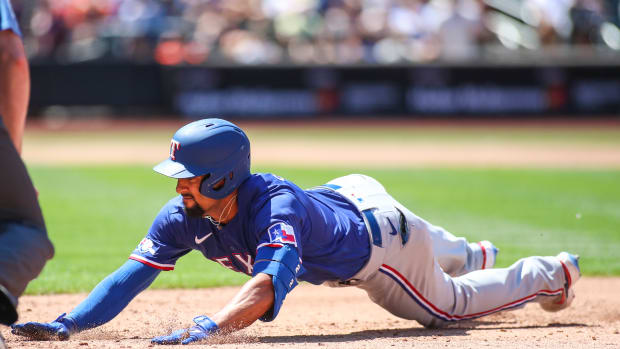 Jul 3, 2022; New York City, New York, USA; Texas Rangers second baseman Marcus Semien (2) dives back to first after hitting a single in the third inning against the New York Mets at Citi Field. Mandatory Credit: Wendell Cruz-USA TODAY Sports