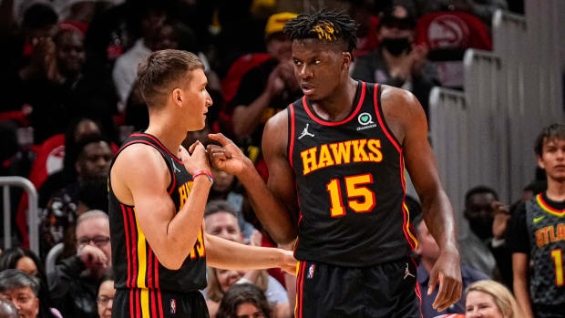 Apr 13, 2022; Atlanta, Georgia, USA; Atlanta Hawks center Clint Capela (15) reacts with guard Bogdan Bogdanovic (13) after scoring a basket against the Charlotte Hornets during the first half at State Farm Arena.
