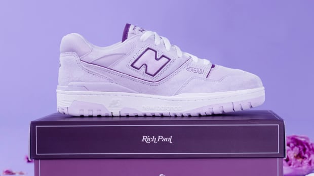 Side view of a purple and white New Balance sneaker.