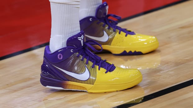 View of purple and gold Nike shoes.