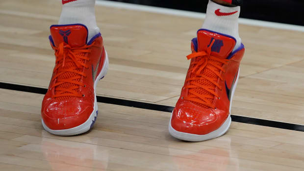 View of orange and purple Nike Kobe shoes.