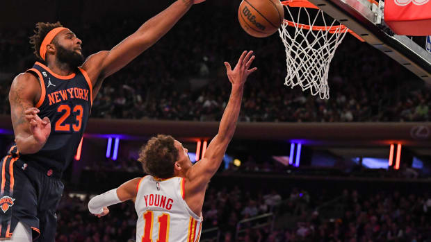 Hawks guard Trae Young attempts a lay up over Knicks center Mitchell Robinson.