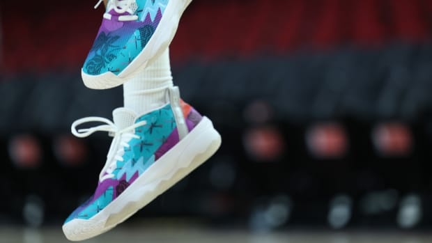 View of teal and purple Adidas Dame shoes.