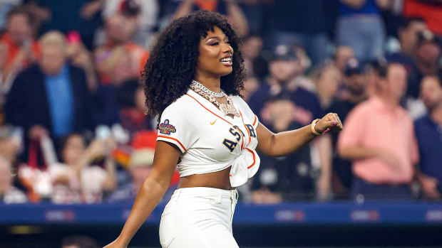 Megan Thee Stallion walks onto the Astros' field to throw a ceremonial first pitch.