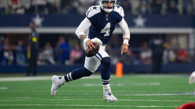 Dallas Cowboys quarterback Dak Prescott runs with the football.