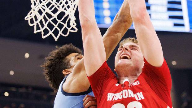 Wisconsin forward Steven Crowl dunking the basketball through traffic against Marquette.