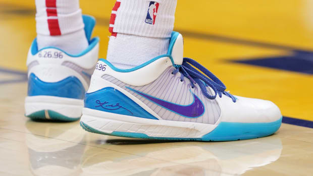 View of white, teal, and purple Nike Kobe shoes.