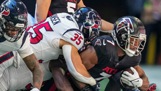 Bijan Robinson is tackled by Houston Texans linebacker Jake Hansen (35) during the first half at Mercedes-Benz Stadium.