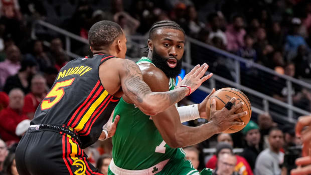 Boston Celtics guard Jaylen Brown dribbles into Atlanta Hawks guard Dejounte Murray.